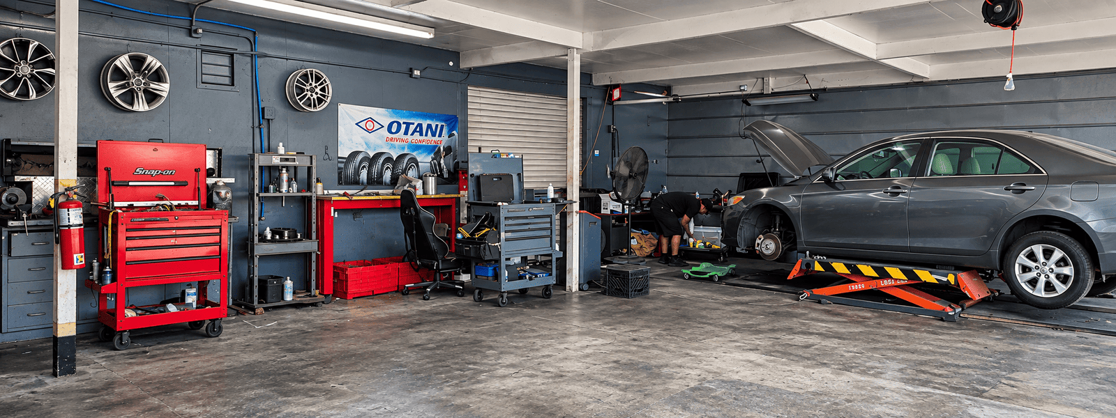 Inside the ER Auto Service repair bay, with a vehicle up on the lift and technician equipment